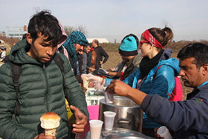 Young Pakistani receiving food from volunteers